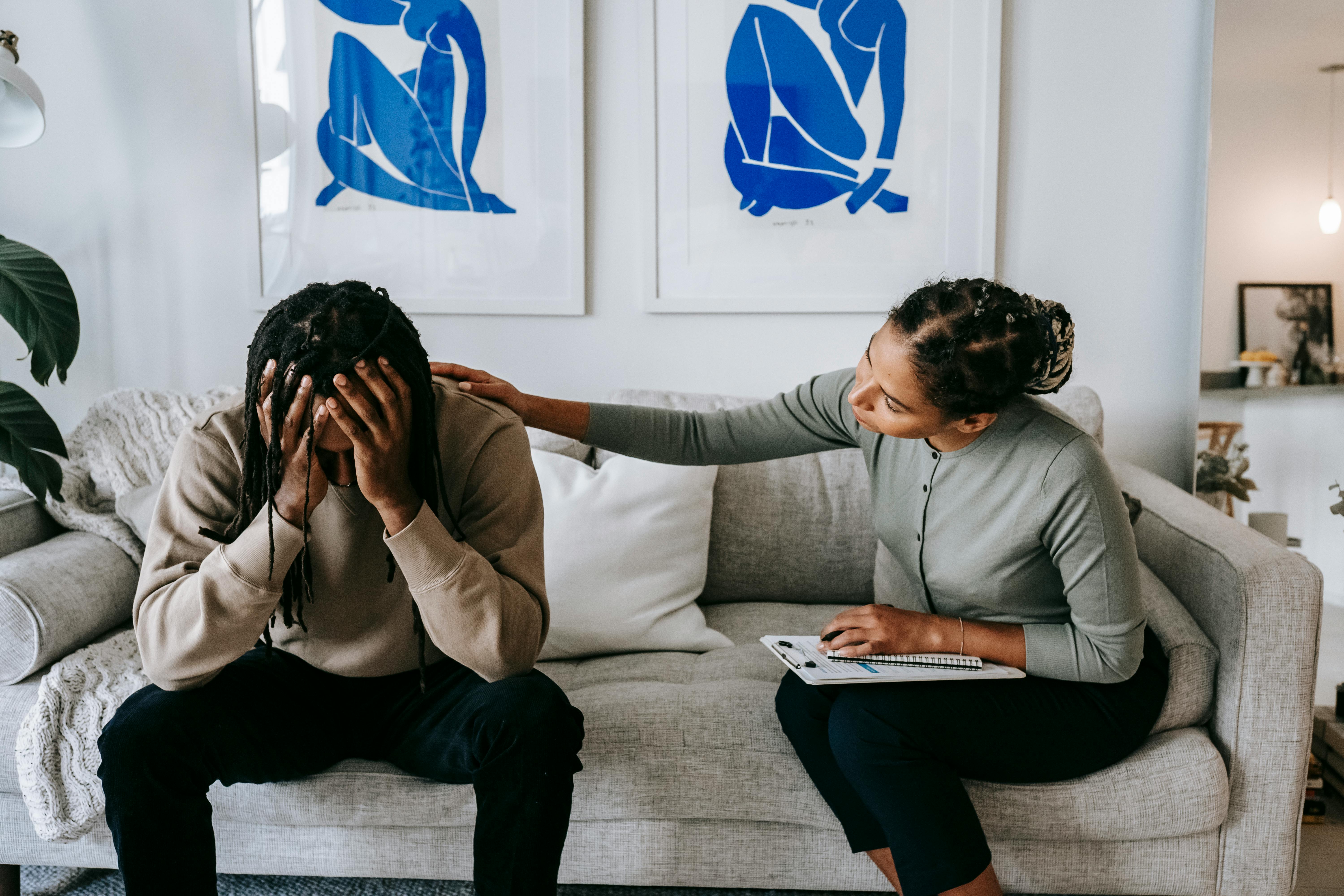 Woman comforts sad man on the sofa